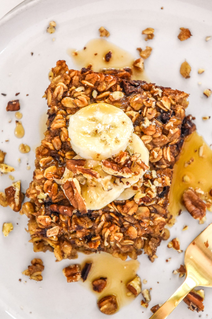 banana bread baked oatmeal with sliced bananas, chocolate chips and syrup on top.
