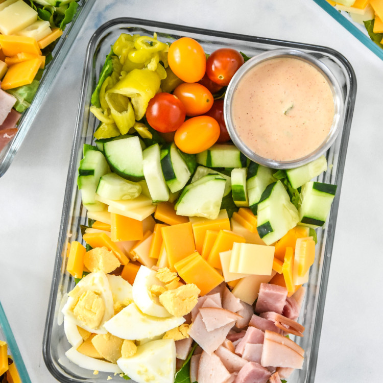 easy chef salad meal prep with dressing cup in a glass meal prep container.