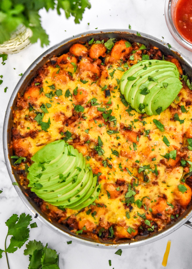 the one-pan soy chorizo gnocchi skillet baked and topped with cilantro and avocado.