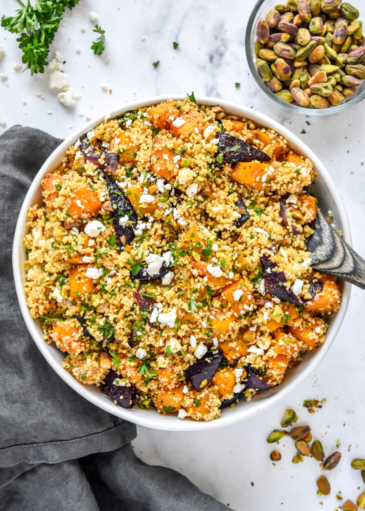 bowl of Roasted Butternut Squash Couscous Salad with a wooden spoon.