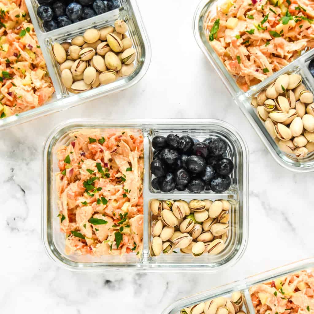 Easy Buffalo Chicken Salad Meal Prep with blueberries and pistachios in a glass meal prep container.