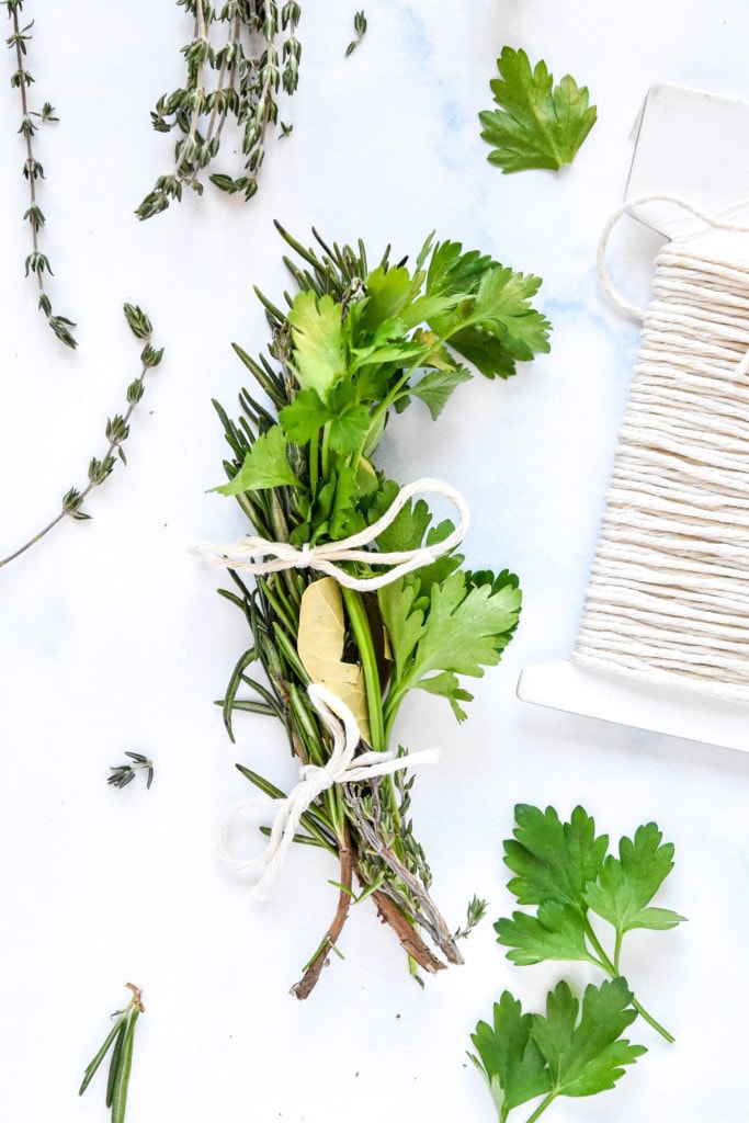 fresh herbs and a bay leaf tied together with kitchen twine to make a bouquet garni.