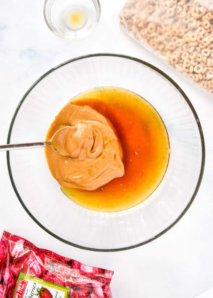 mixing peanut butter and honey together in a large glass bowl.