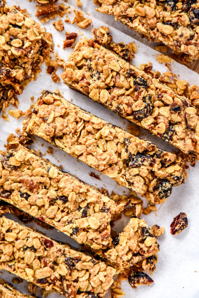 sliced chewy cinnamon granola bars on a cutting board with parchment paper.