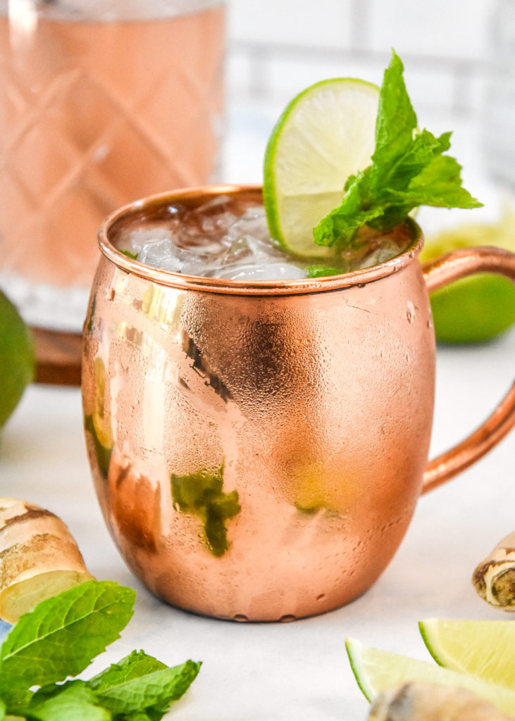 moscow mule in a copper mug with lime and mint garnish.