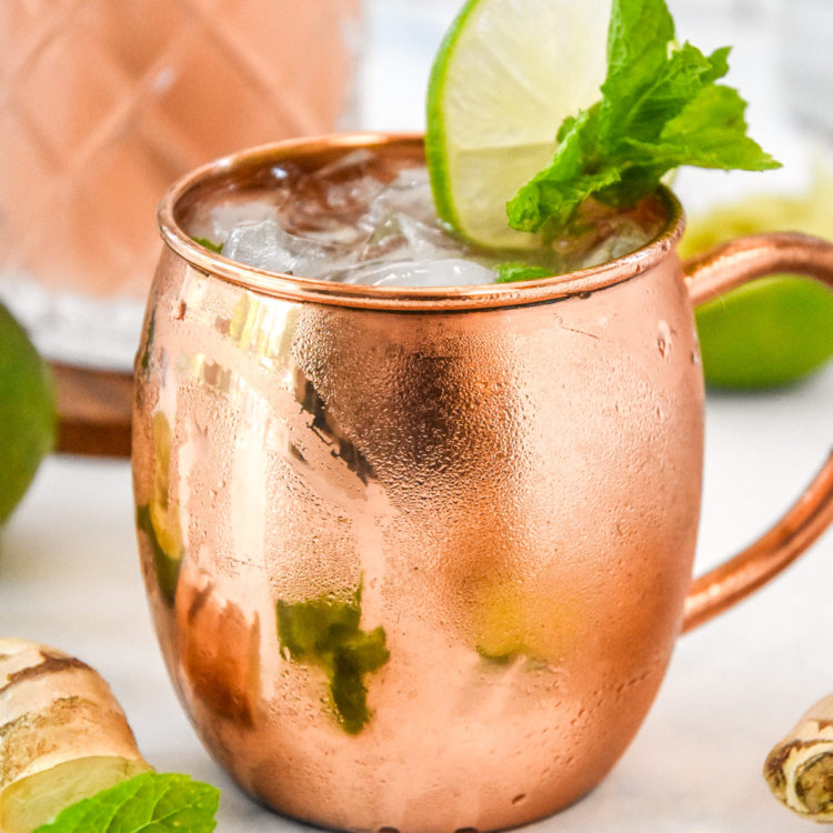 moscow mule in a copper mug with lime and mint garnish.