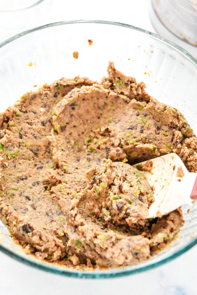 mixing black bean burger batter together in a glass bowl.