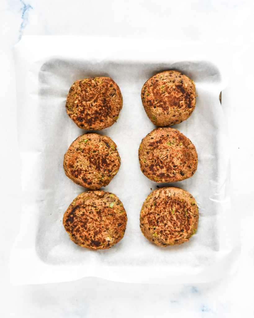 cooked freezer friendly black bean burgers on a sheet tray to be frozen for storage.