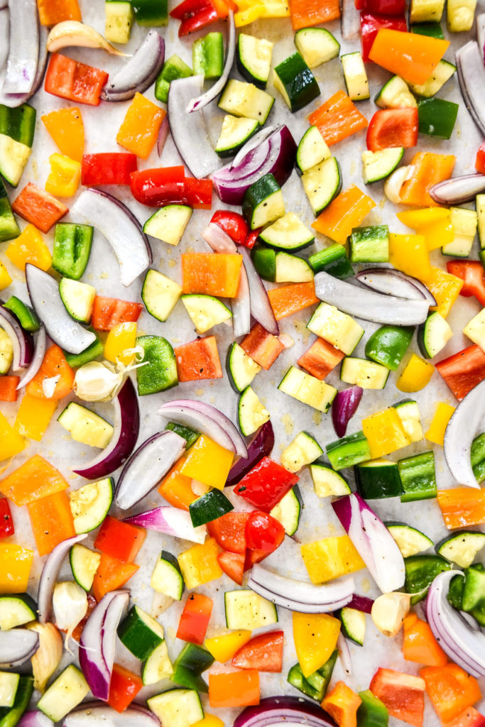 cut veggies spread on a sheet pan in a single layer before roasted.