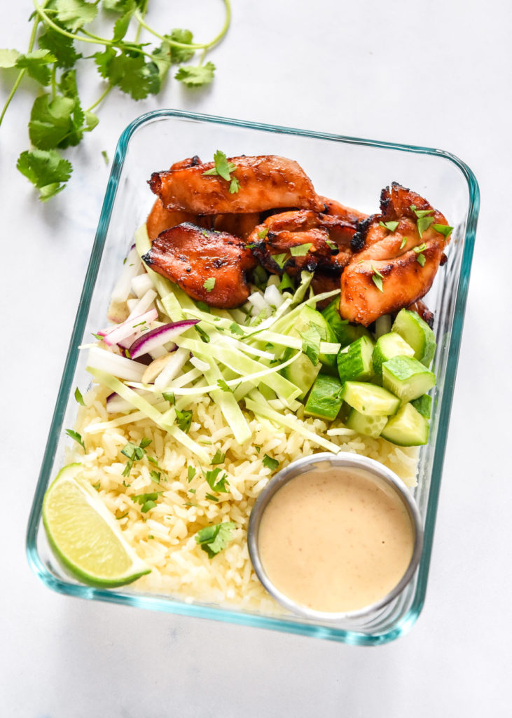 air fryer honey sriracha chicken bowls packed in glass meal prep containers.