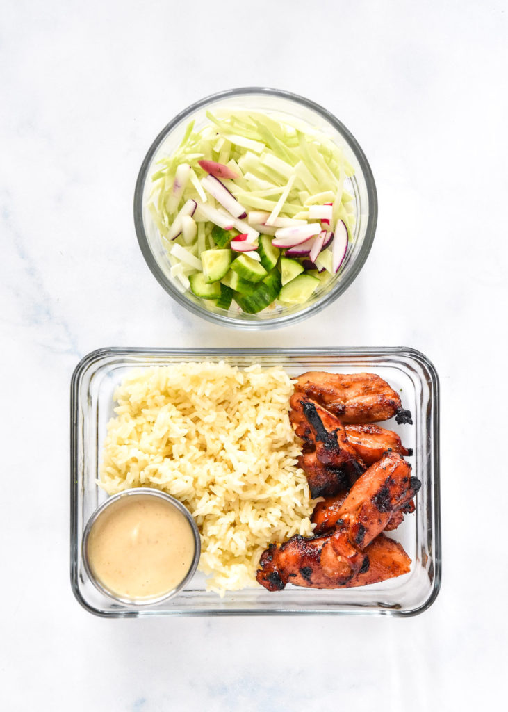 air fryer honey sriracha chicken bowls packed in glass meal prep containers.