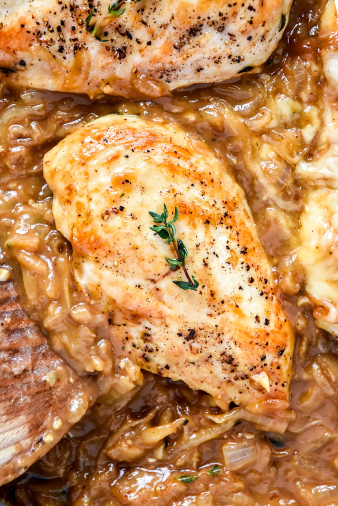 french onion baked chicken breasts in a pan with caramelized onions.