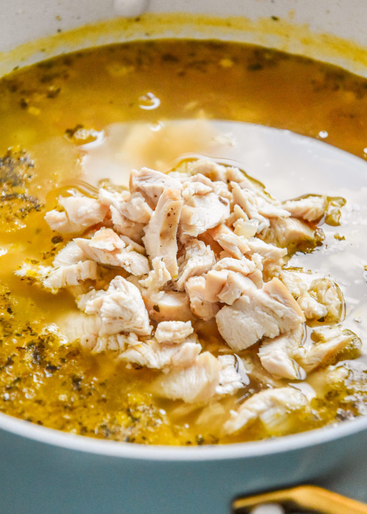 sliced and cut chicken breast added into a soup pot.