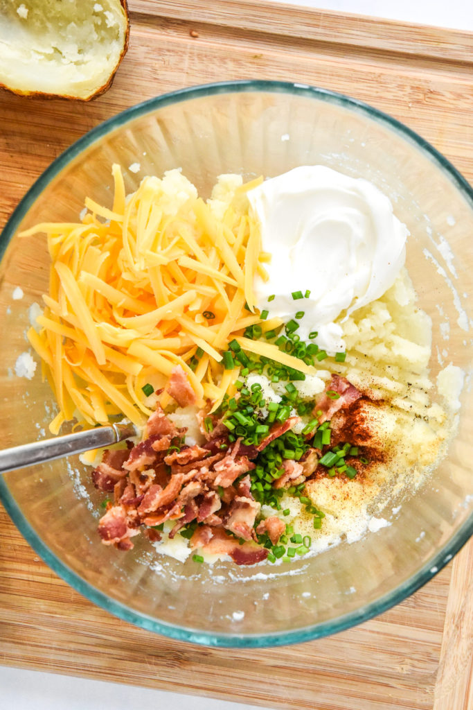 filling with cheese and bacon in a glass bowl for air fryer twice baked potatoes.