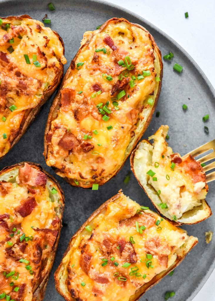 cooked air fryer twice baked potatoes with one sliced open.