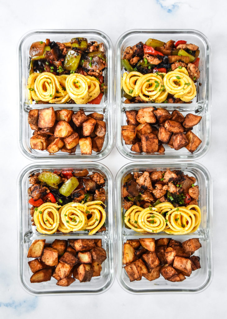 top view of 4 crispy potato egg ribbon breakfast bowls in glass meal prep containers.