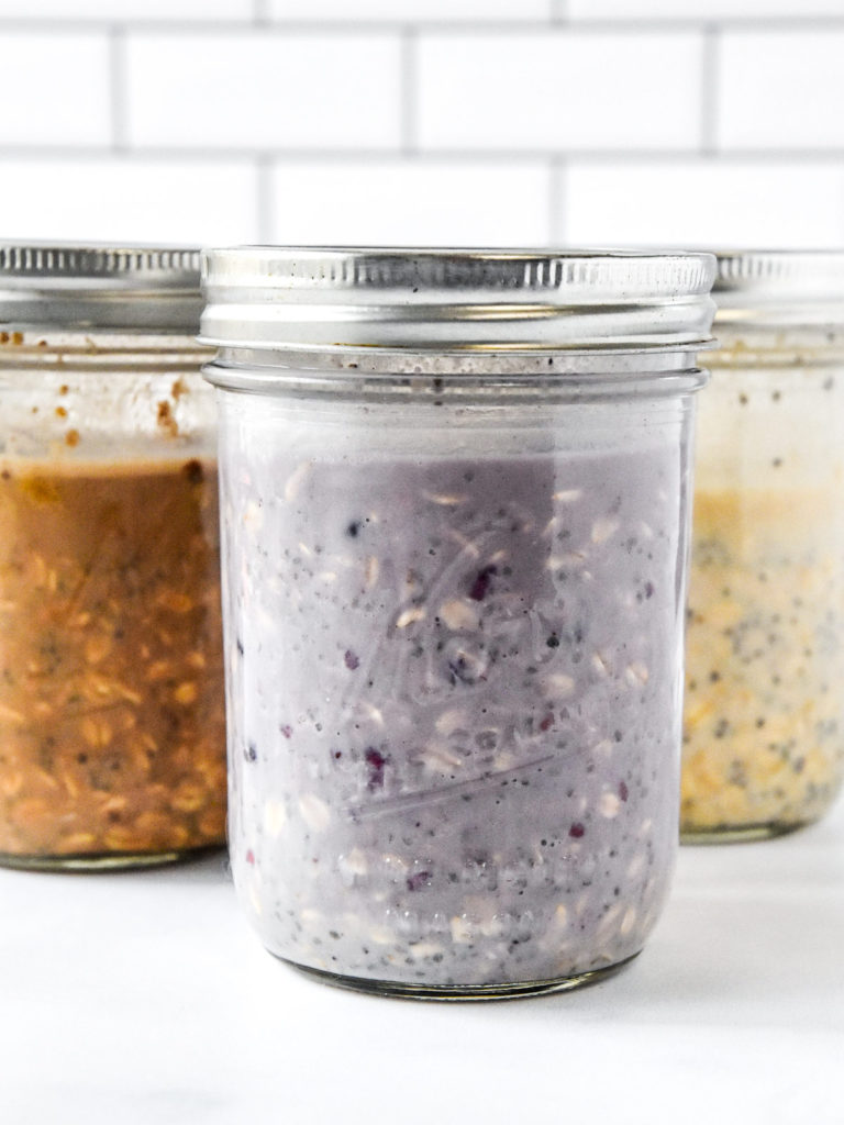 3 glass mason jars of overnight oats with lids on.