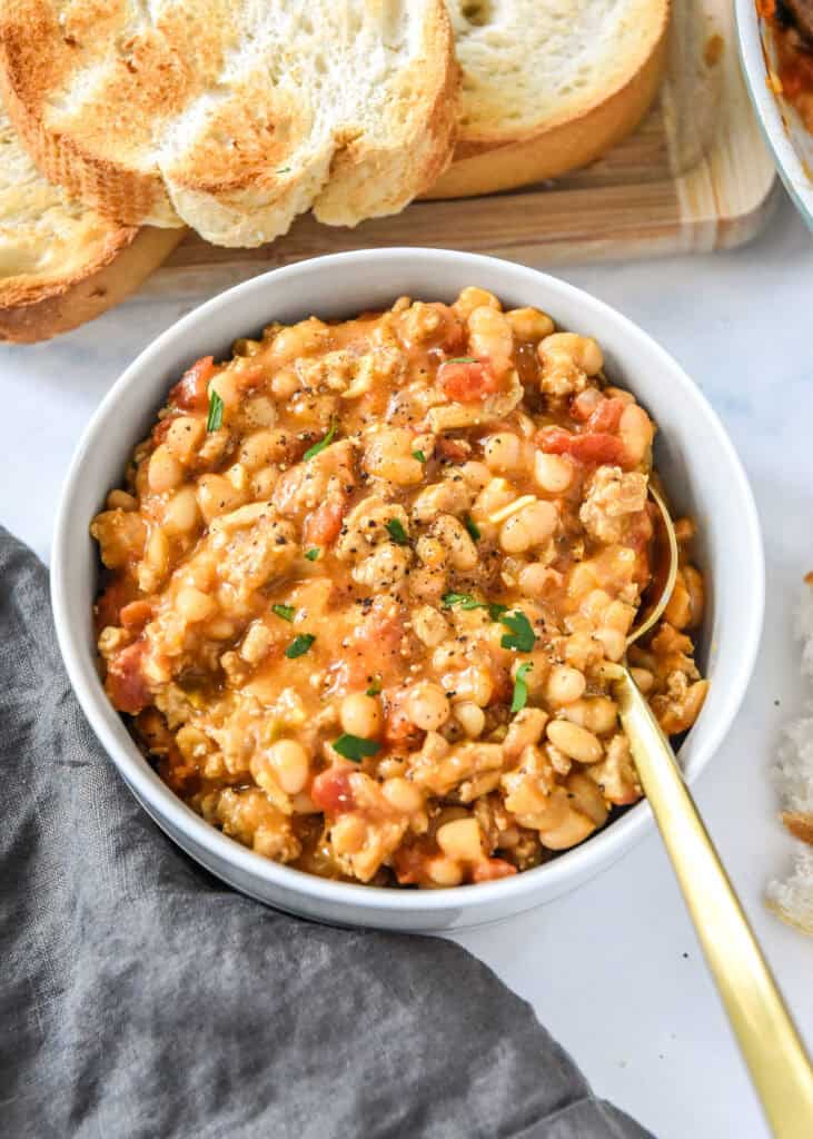 sloppy ground turkey white bean skillet dished up in a bowl with spoon.