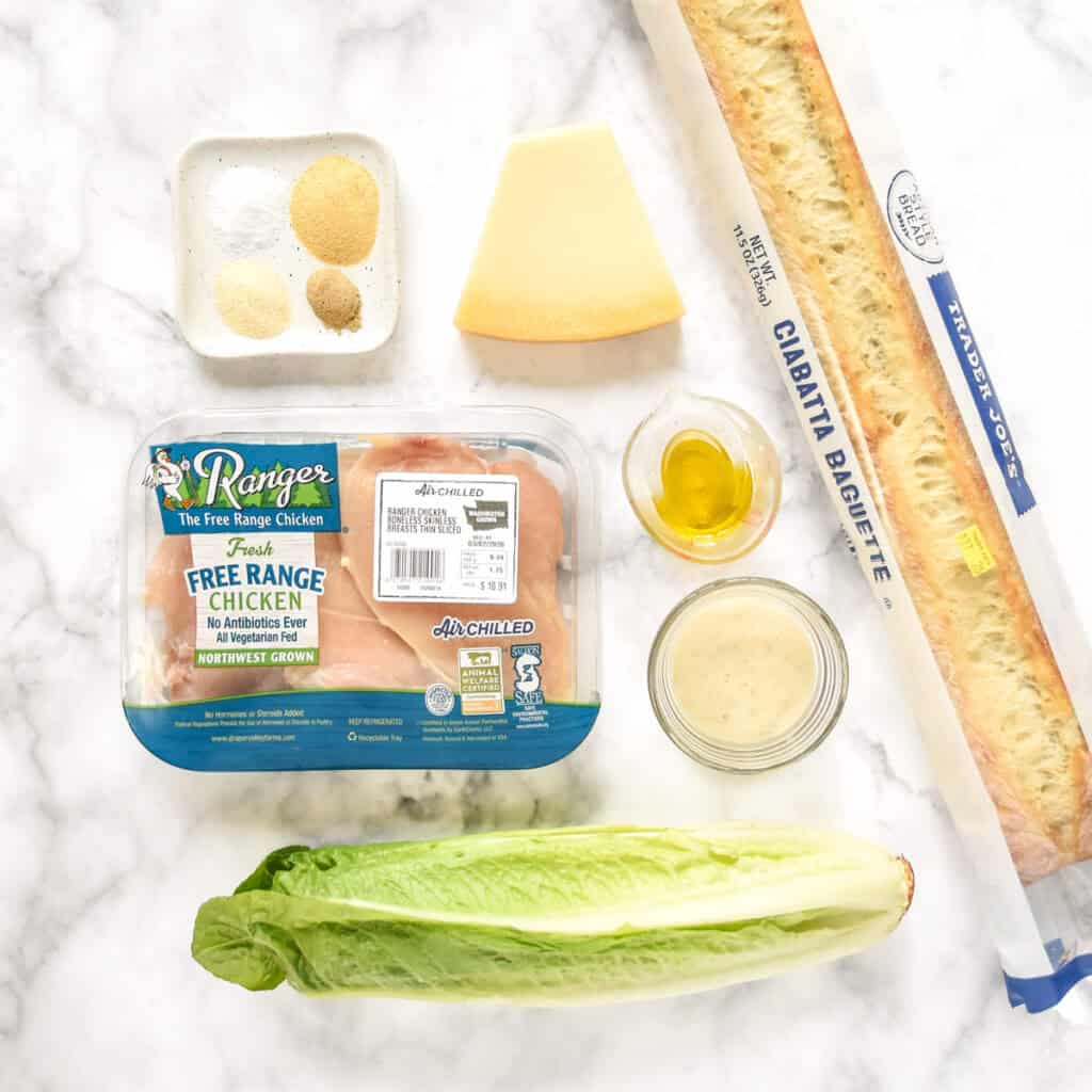 ingredients on a counter surface for the caesar salad chicken sandwiches.