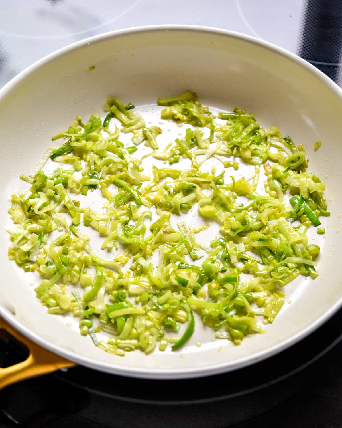 cooked sliced leek in a nonstick pan.