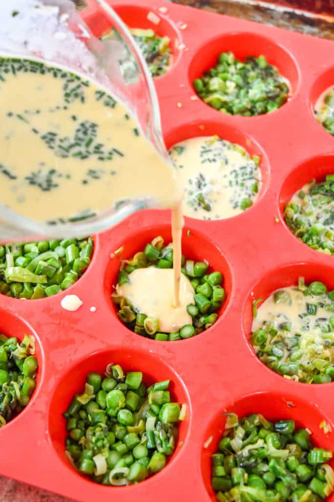 pouring quiche custard mixture into the muffin tin.