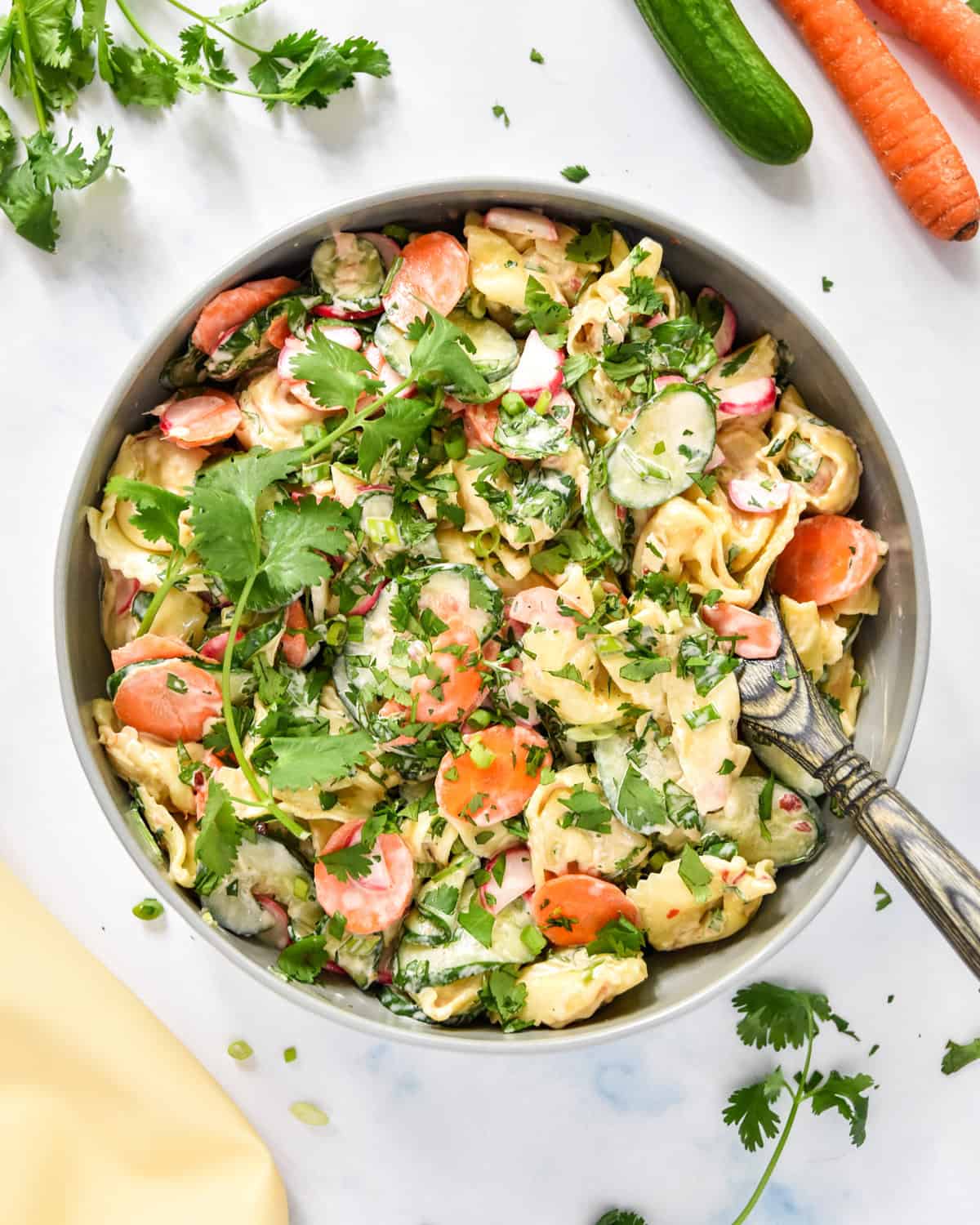 banh mi inspired tortellini salad in a large serving bowl with wooden spoon.