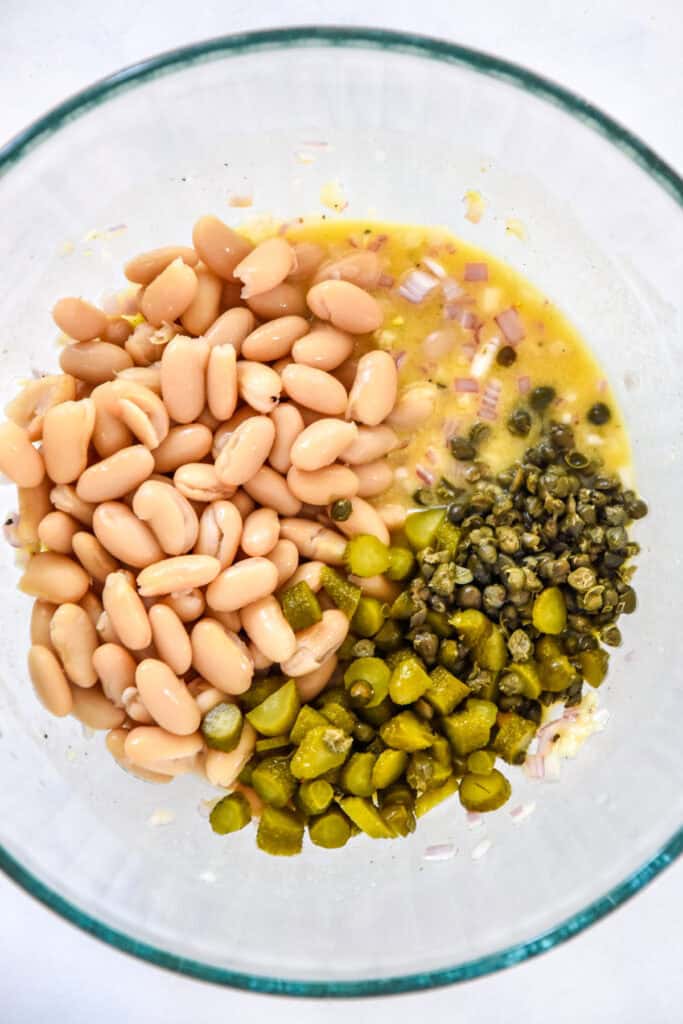 beans, capers and dressing in a large glass bowl before stirring.
