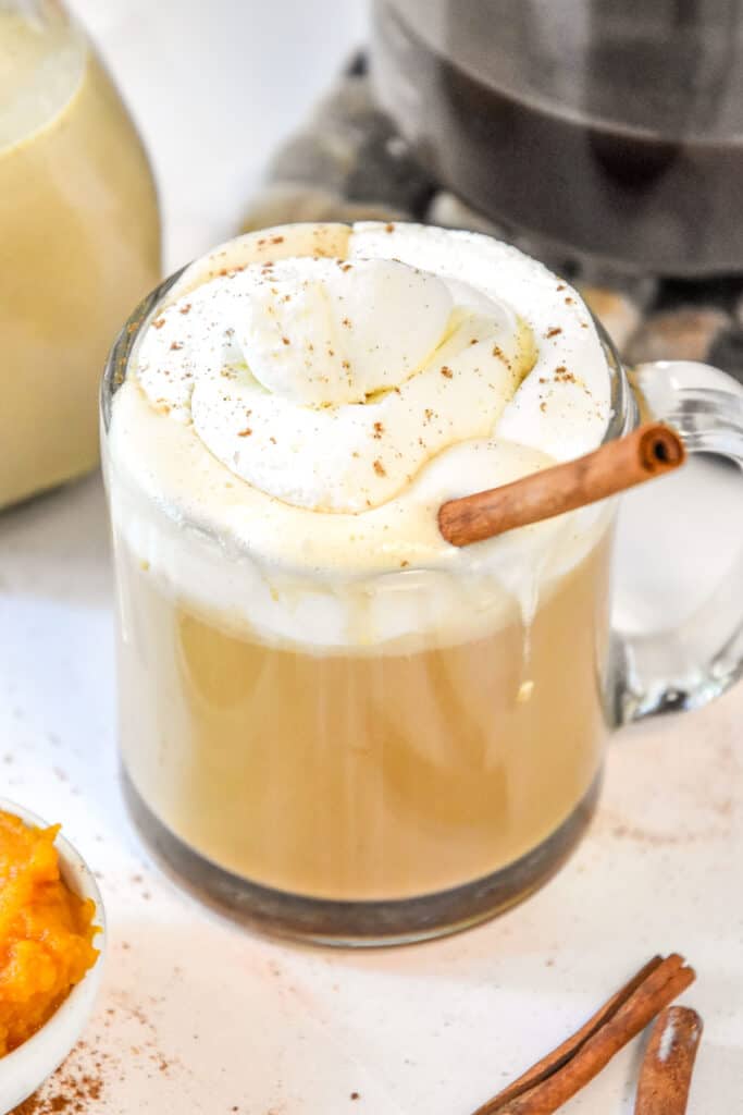 homemade pumpkin spice coffee creamer in a cup of coffee with whipped cream on top.